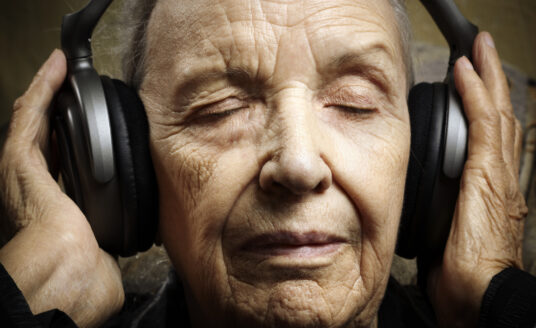Bethesda music therapy for seniors can range from listening to music, like the senior in this photo, or playing music! The benefits of music therapy for seniors include improved memory and reduced stress.