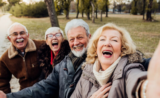 Group of senior friends at a retirement community. Studies have shown that seniors live longer at retirement communities - and they are happier too!