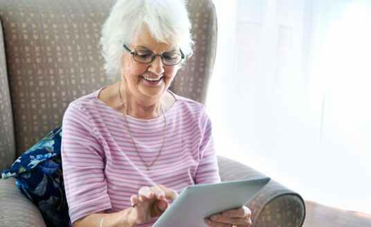 Technology helps seniors stay in touch with loved ones - no matter where they live! This senior woman uses a tablet to connect with her family.