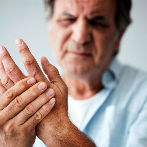 Senior man holds his hand, as he's suffering from arthritis pain. Read these tips from Bethesda to manage arthritis pain during the winter months.