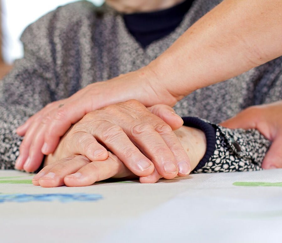 A family caregiver takes the responsibility of caring for their child, parent, spouse, or other family member, which can sometimes require family leave. Here, a daughter cares for her senior parent.