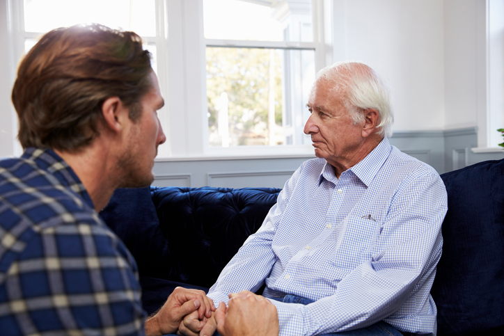 An adult male cares for his senior father, who suffers with dementia. Many caregivers struggle to manage the unpredictable behaviors of dementia.
