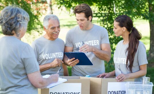 Community involvement is a great way to improve health and happiness in seniors—while benefitting your neighborhood! Here, a group of senior and adult volunteers collect donations.