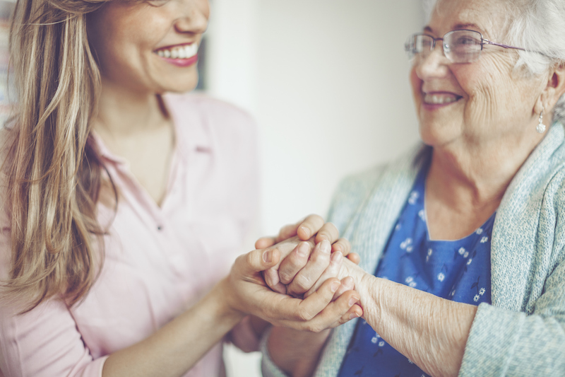 A friendly interaction between a senior woman and a woman who works in senior care. A career in senior care is rewarding because you are able to help others and form meaningful relationships, like the one found in this picture.