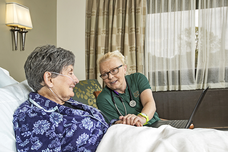 A nurse explains to a senior woman what hospice care does