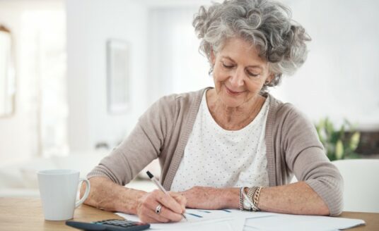 A senior woman reviewing her caregiving schedule, as time management is crucial for a family caregiver.