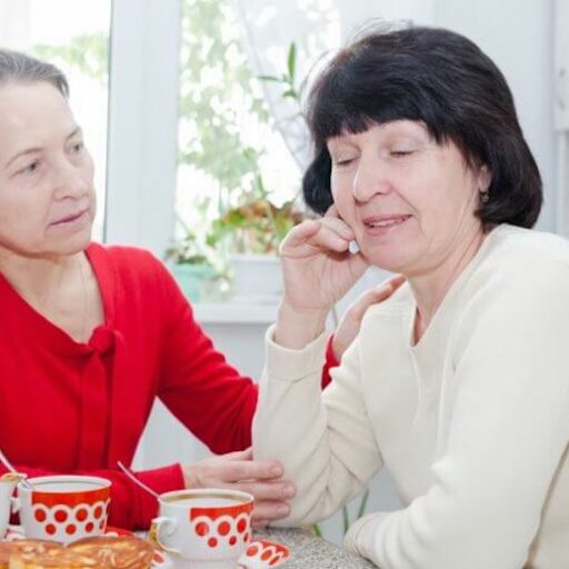 Two senior women discuss a dementia diagnosis