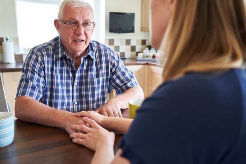 A woman talks to her senior father about dementia.