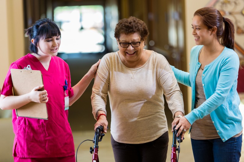 A Care Manager walks with a senior woman and her daughter. Providing a complete geriatric assessment is only one of the ways a care manager can help a family caregiver.