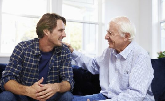An adult man has a pleasant conversation with his father, who is living with Alzheimer's.