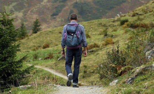 A man walks down a path, as spending time in nature is helping him move forward after his loved one died.