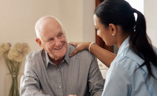 A senior man chats with a nurse, one of the many people you will meet at an assisted living community.