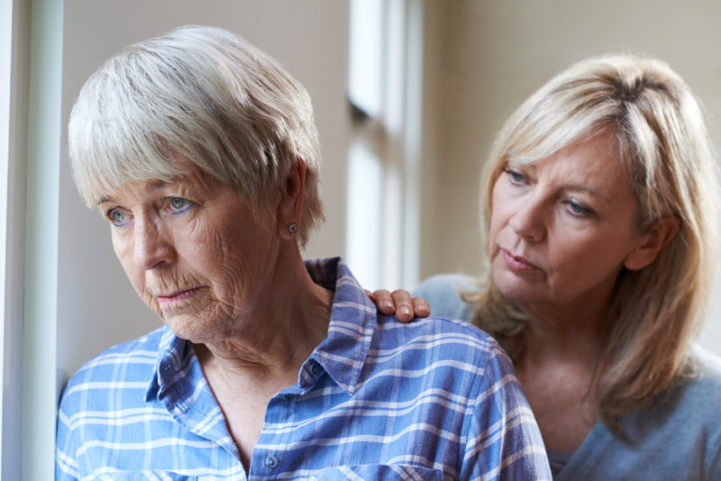 An adult woman talks with her mother as they consider memory care.