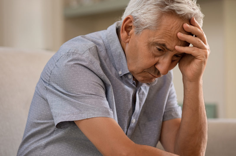 Elderly man looks stressed as he struggles with how to fight loneliness as a senior.