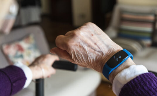 The hand of a senior brandishing their smart watch, one of many great gadgets for seniors with alzheimer's and dementia
