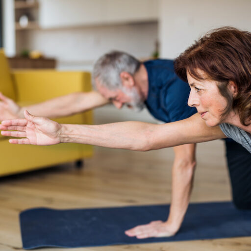 A senior couple stretching for an in-home exercise designed for elderly seniors