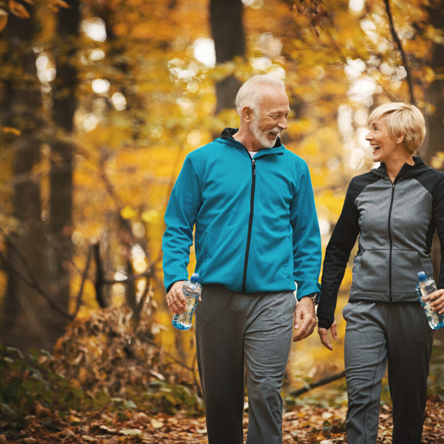 Senior couple walking as a healthy living tip during the fall season.