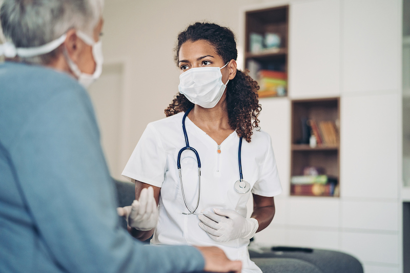 Young female doctor talking to a senior patient at annual checkup