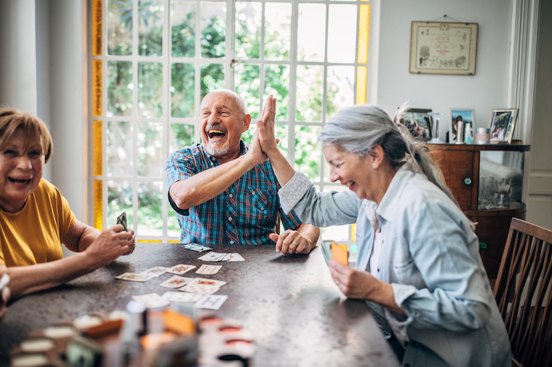 Group of older adults playing cards as a hobby..