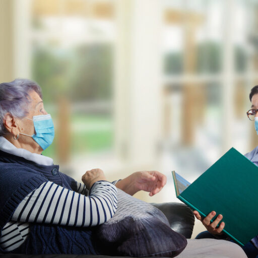 Caregiver assessing dementia patient for COVID-19.