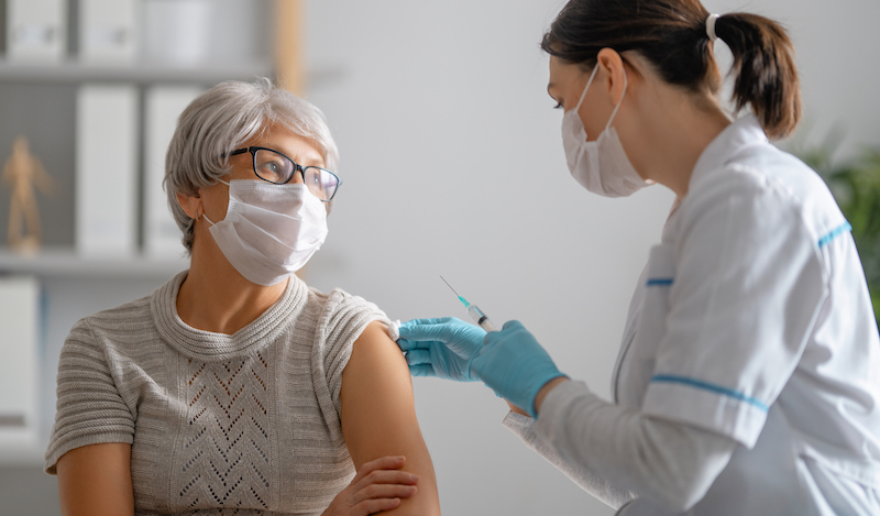 Doctor giving a senior woman a vaccination.
