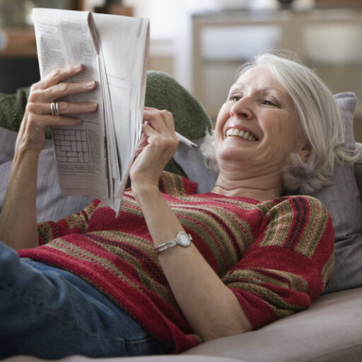 Senior woman staying sharp with mental exercises like Crossword Puzzles.