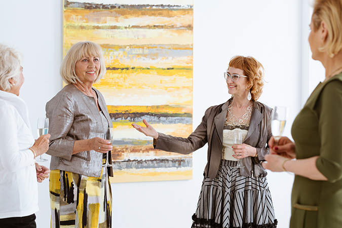 Women in a museum viewing a painting