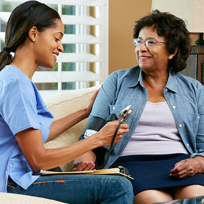 A young female nurse for Care in Your Home offers home care to a senior woman in her living room