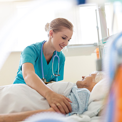 A senior woman receives help from a female nurse in hospice care