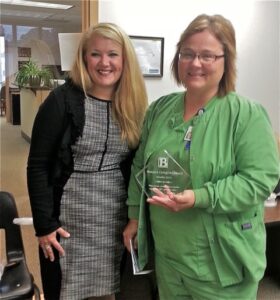 Kelly Karavousanos, Grief Services Manager at Baue present award to Shelby Harp