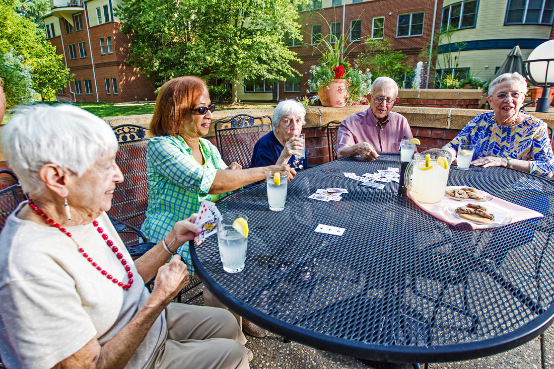 A group of senior women sitting outside at a patio table at Bethesda Orchard