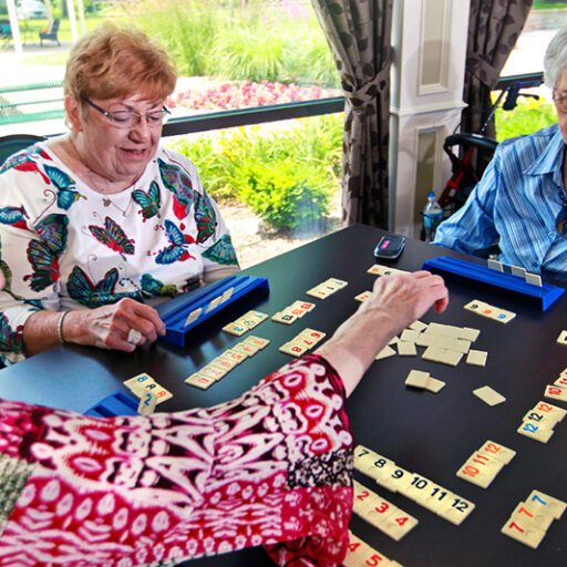 A group of three senior women enjoy a game of Rummikub at Bethesda Terrace