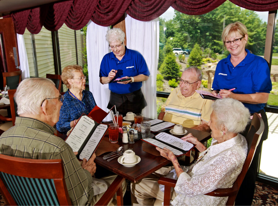 Two senior women and two senior men order dinner from two young servers at Bethesda Terrace