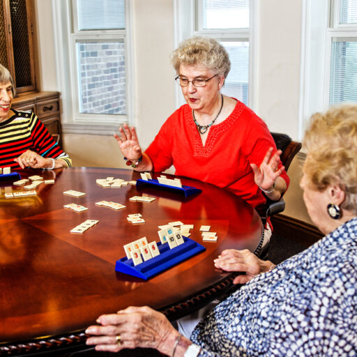 Women playing a table game and making new senior friends