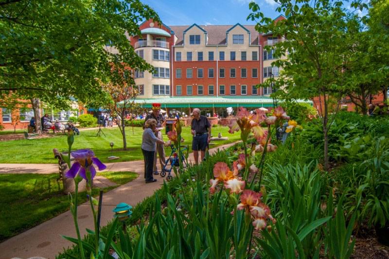 Seniors chat in a lush garden at Bethesda Orchard