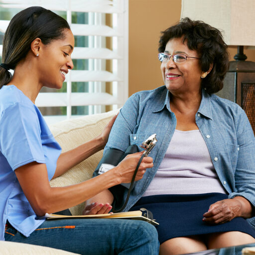 A senior woman receives home health care from a young female nurse