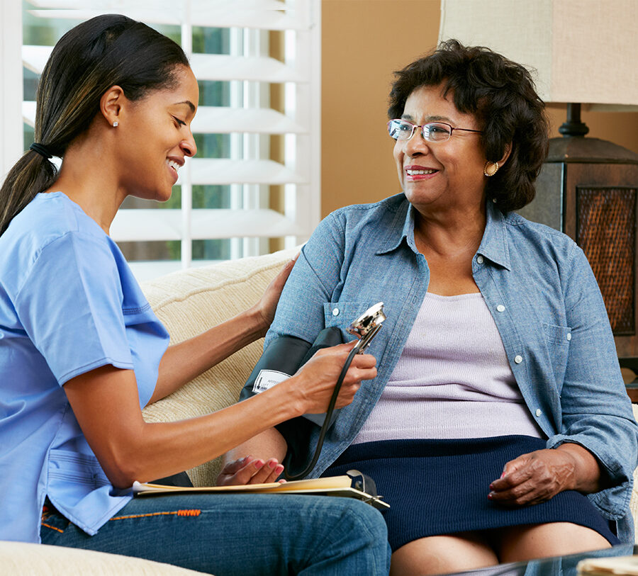 A senior woman receives home health care from a young female nurse