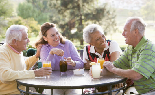Group of senior friends at a retirement community. Studies have shown that seniors live longer at retirement communities - and they are happier too!