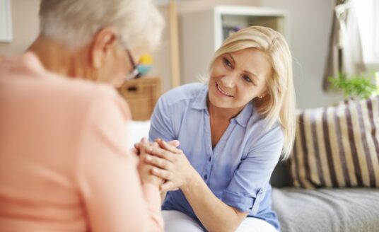 An adult woman talks to her senior monther, as they consider planning for the future.