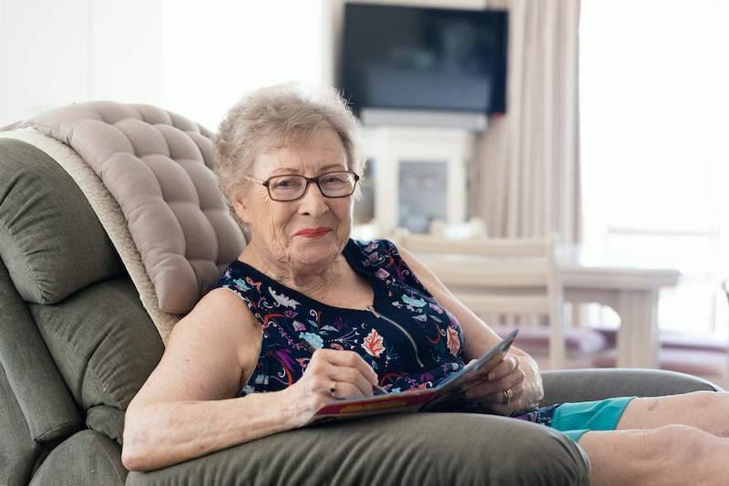 Older woman enjoying senior independence as she is seated in a comfortable recliner in her own home