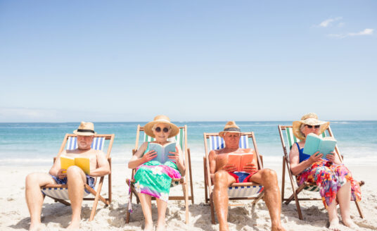 Traveling seniors relaxing at the beach