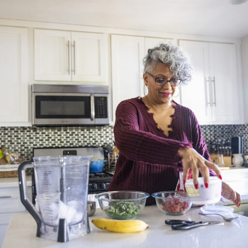An older women preparing meal preps for senior caregivers in her kitchen