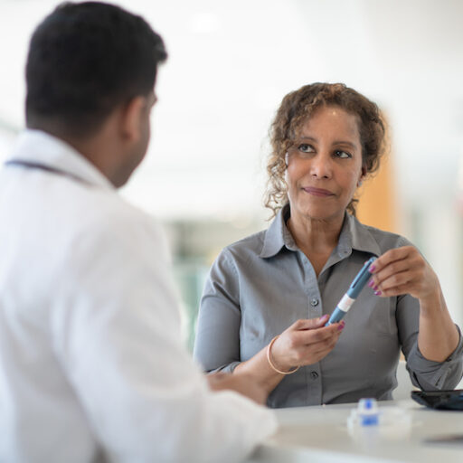A doctor provides insulin and discusses a new diabetes diagnosis with a female patient
