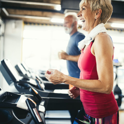 A senior woman runs on a treadmill to control high blood pressure.