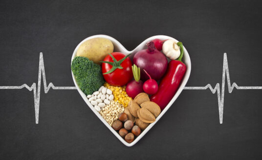 Heart-healthy foods inside the shape of a heart, with a pulse line going through the horizontal center.