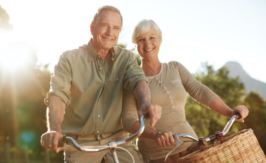 A senior man and woman avoid cognitive decline by getting exercise on a bike ride.