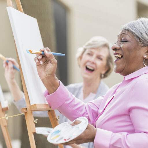 two senior women painting during art therapy