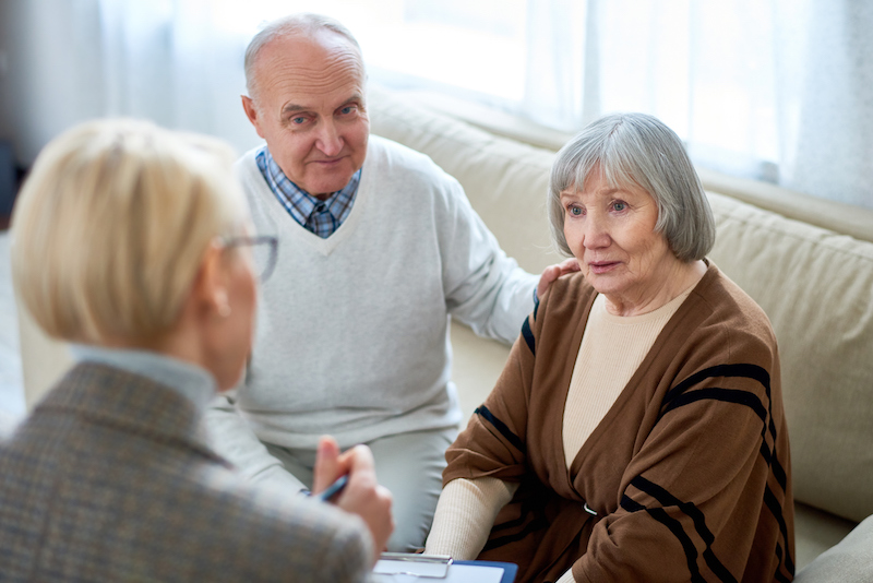 woman consulting with a senior couple about an assisted living community
