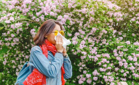 Woman blowing her nose due to allergies this season