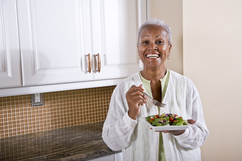 senior women eating a salad and focusing on foods that make you happy